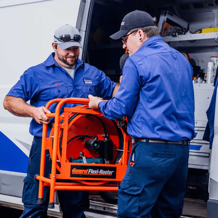 Techs loading a plumbing sewer tool